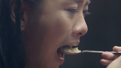泣きながらご飯を食べる少女