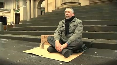 街中に座るホームレスの男性